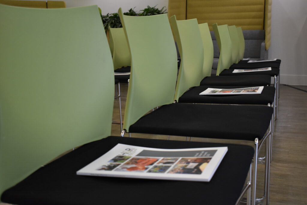 Green and black chairs with the Annual Report and Accounts Summary document at the AGM.