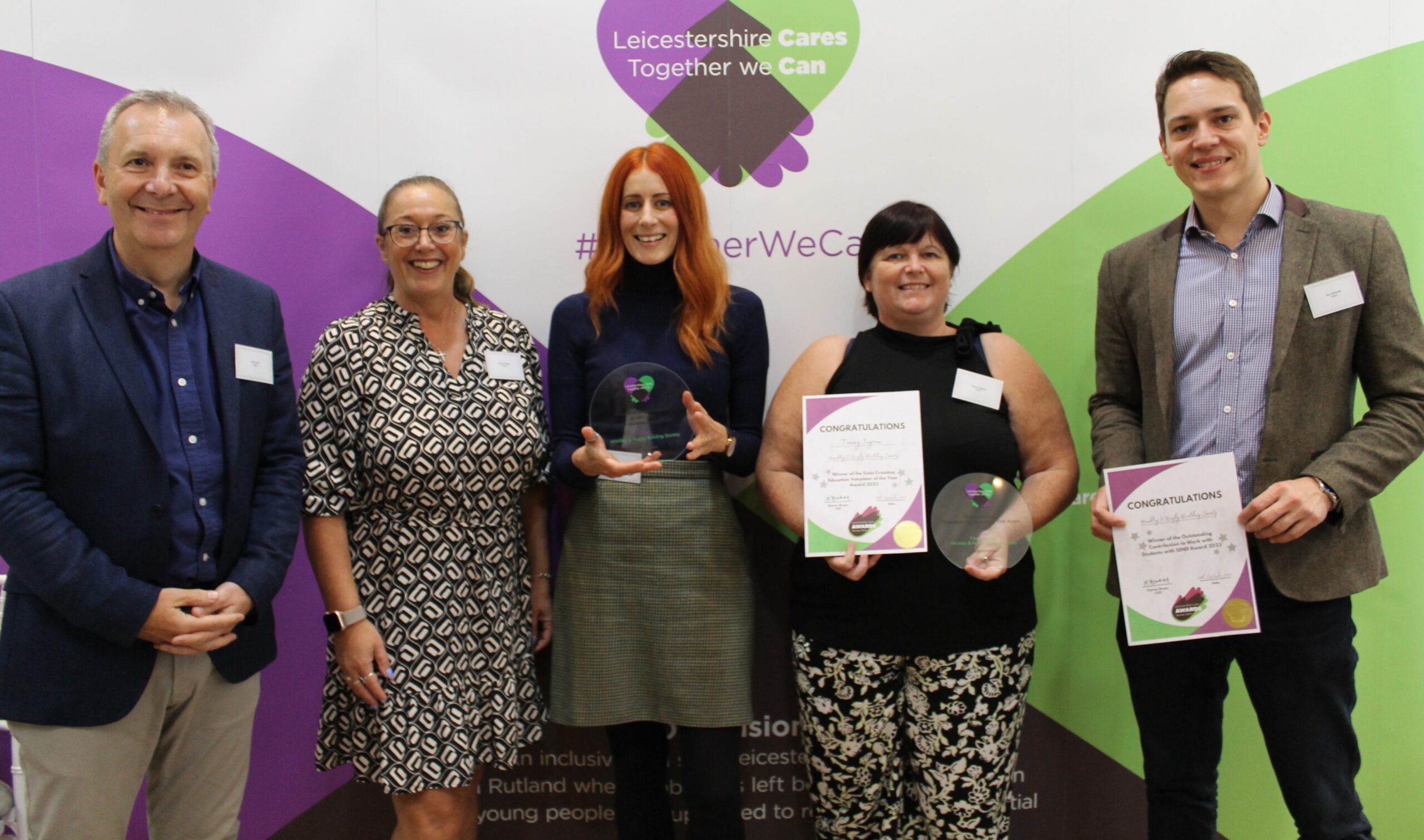 Image of five Hinckley & Rugby Building Society colleagues at Leicestershire Cares Awards ceremony 2023. Colleagues are holding the awards that have been won.