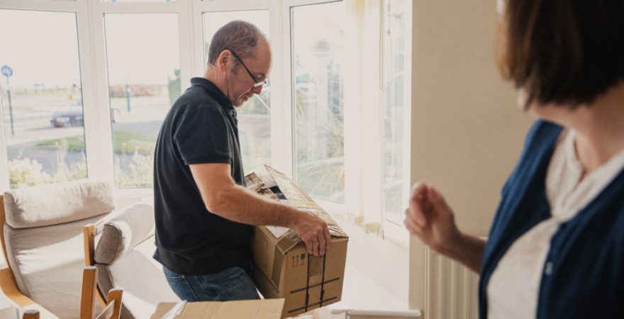 Middle aged couple packing boxes in their home.
