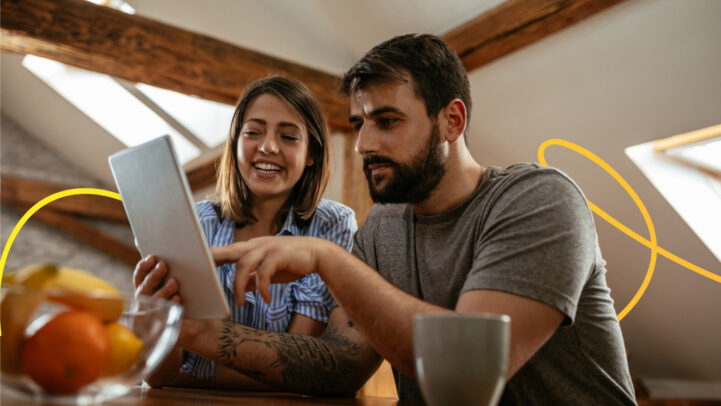 A couple looking at opening a joint savings account together by looking through paperwork.
