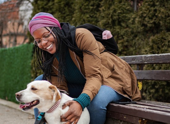 Young adult woman enjoying a companionship moment with her dog on a bench